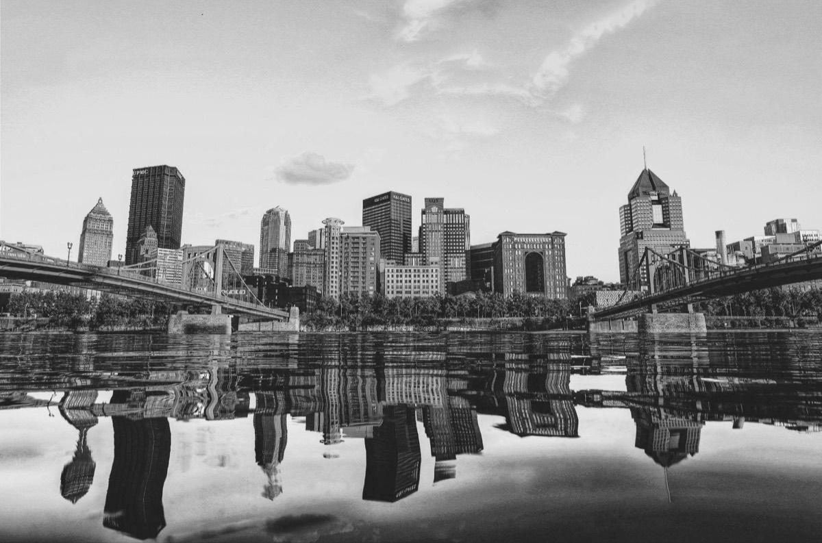 A Midwest city skyline reflected in still river water
