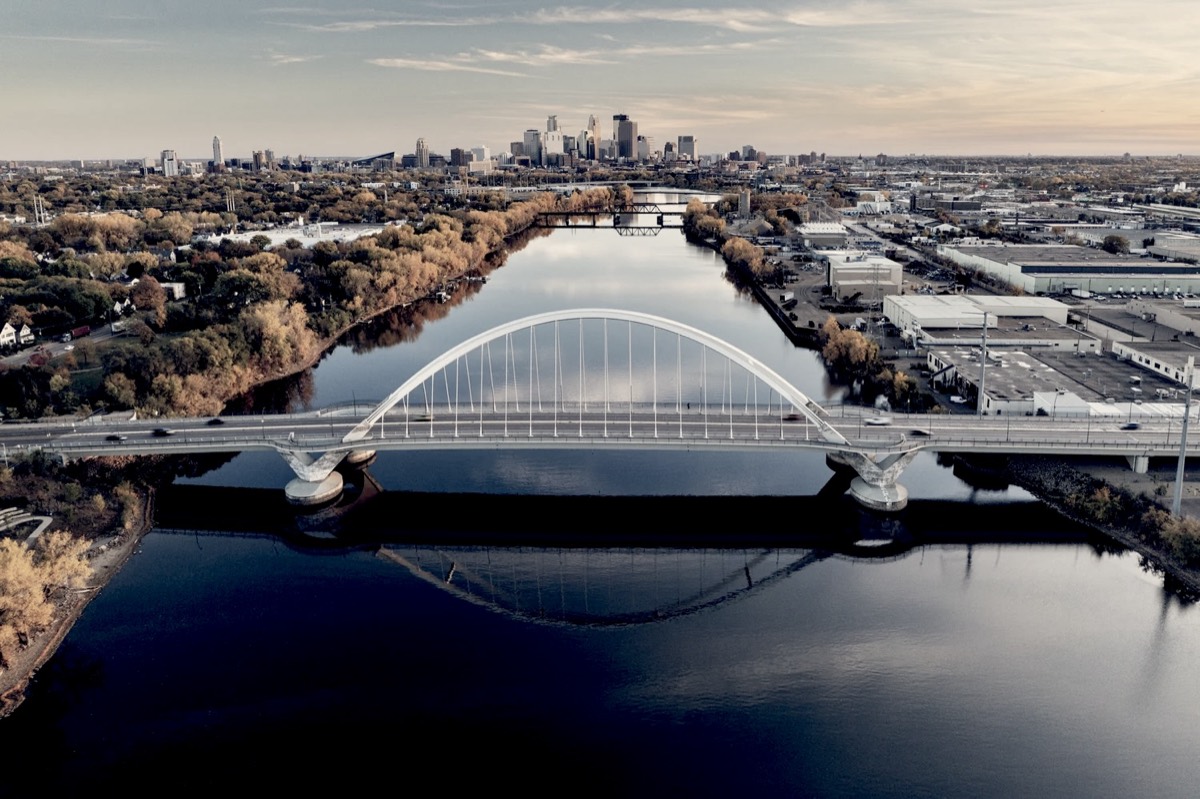 An arch bridge over the Mississippi with the Minneapolis skyline beyond